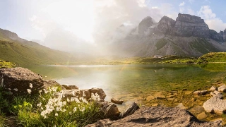 bEin Bild von einer Urner Berglandschaft mit einem idyllischen Bergsee im Zentrum.